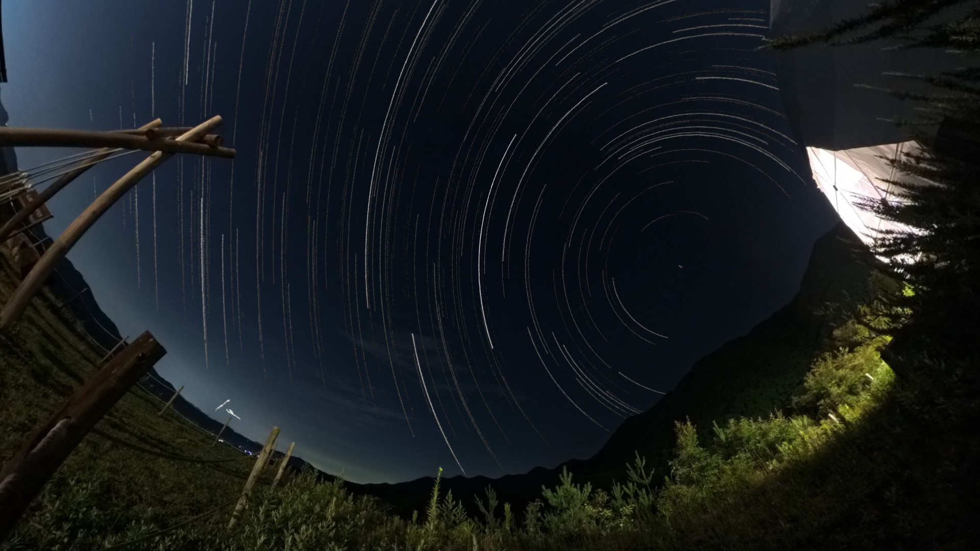 山上の夜空に弧を描く星の軌跡